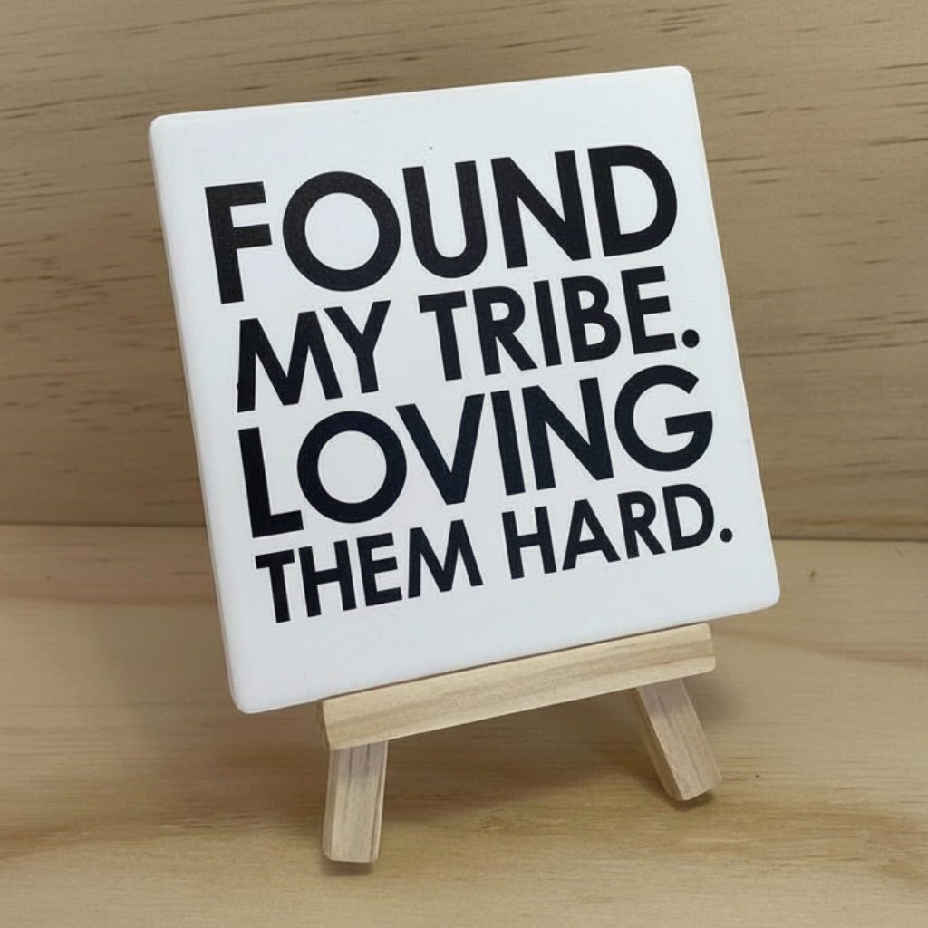 Let's Be Frank Australia square ceramic coaster with Found My Tribe quote on a small wooden display easel